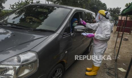   Petugas pengecekan kepada pengguna kendaraan saat tes cepat (rapid test) COVID-19 dengan sistem drive thru 