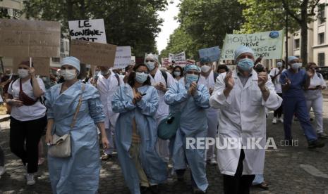 Pekerja rumah sakit menghadiri demonstrasi Selasa, 16 Juni 2020 di Paris. Pekerja rumah sakit Prancis dan lainnya memprotes di kota-kota di seluruh negeri untuk menuntut pembayaran yang lebih baik dan lebih banyak investasi dalam sistem rumah sakit umum Prancis, yang dianggap di antara yang terbaik di dunia tetapi berjuang untuk menangani aliran pasien virus setelah bertahun-tahun pemotongan biaya