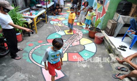 Anak-anak bermain permainan tradisional ular tangga. Permainan tradisional selalu menarik perhatian siswa karena sederhana