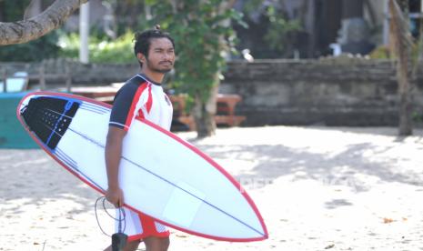 Peselancar I Ketut Agus Aditya Putra bersiap melakukan latihan di Pantai Legian, Badung, Bali, Senin (12/7/2021). Tim surfing Indonesia akan mengirimkan dua orang atletnya pada Olimpiade Tokyo yaitu Rio Waida yang telah dinyatakan lolos kualifikasi serta I Ketut Agus Aditya Putra sebagai atlet alternate atau atlet pengganti yang memiliki kemungkinan bertanding di Olimpiade Tokyo apabila ada atlet lain yang telah lolos kualifikasi namun tidak dapat bertanding karena sakit atau mengalami cedera. 