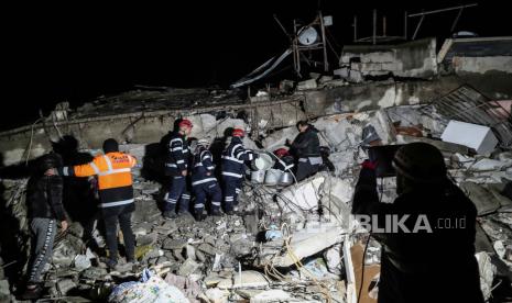 Personil darurat selama operasi pencarian dan penyelamatan di lokasi bangunan yang runtuh setelah gempa bumi di distrik Iskenderun Hatay, Turki, (06/02/2023). Presiden Turki Recep Tayyip Erdogan mengumumkan pada Senin (6/2/2023), negara itu akan memperingati tujuh hari berkabung nasional setelah gempa bumi mematikan melanda beberapa provinsi selatan.