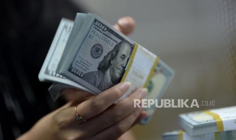 Karyawan menghitung mata uang dolar AS.