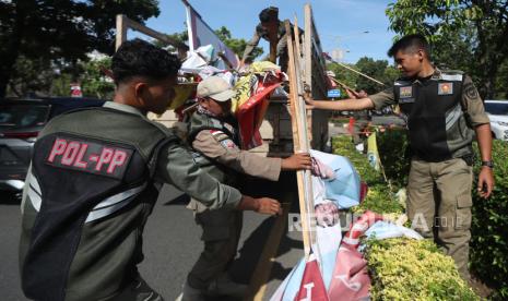 Panitia pengawas pemilihan (panwaslih) dan Satpol PP Kota Banda Aceh menertibkan alat peraga kampanye (APK) caleg, DPD, capres dan cawapres serta partai politik (parpol) peserta pemilu 2024 di Banda Aceh, Aceh, Kamis (11/1/2024). Penertiban APK tersebut dilakukan karena pemasangannya tidak sesuai dengan peraturan KPU, memasang di jalan protokol, memaku dipohon dan menggunakan tiang listrik, telkom serta tiang rambu lalulintas. 