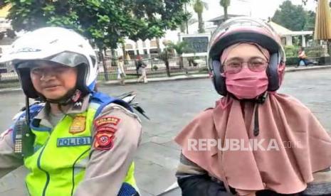 Seorang ibu ngidam meminta dibonceng menggunakan motor polisi di Taman Kota Tasikmalaya, Ahad (27/5/2023). 