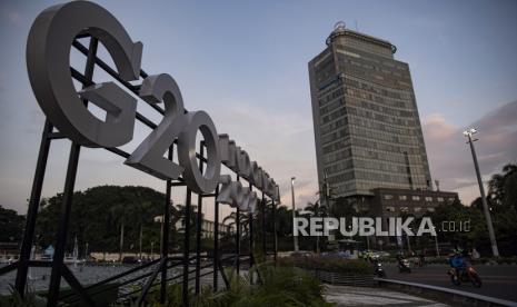 Pengendara motor melintas di samping logo Presidensi G20 Indonesia 2022 di Bundaran HI, Jakarta, Jumat (21/1/2022). Pertemuan para Menteri Luar Negeri (Menlu) G20 atau G20 Foreign Ministers' Meeting (FMM) siap diselenggarakan di Bali pada Kamis-Jumat (7-8/7/2022).