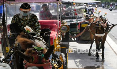 Andong wisata menggunakan sekat plastik transparan untuk kusir dan penumpang di Malioboro, Yogyakarta, Ahad (21/6).  Menyambut normal baru pandemi Covid19, andong wisata di Jogja ikut berbenah