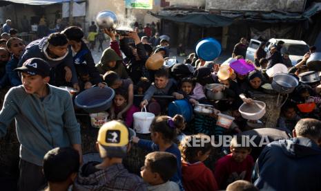 Warga Palestina mengantri untuk mendapatkan makanan gratis di Rafah, Jalur Gaza, pada Selasa, (12/3/2024). 