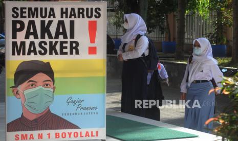 Sejumlah siswa mengenakan masker saat berada di lingkungan sekolah di SMA Negeri 1 Boyolali, Jawa Tengah, Senin (6/9/2021). Pembelajaran tatap muka terbatas bagi siswa sekolah menengah atas tersebut dilakukan dengan adaptasi kebiasaan baru protokol kesehatan COVID-19 serta membatasi kapasitas jumlah siswa 50 persen dengan jadwal masuk sekolah secara bergantian. 