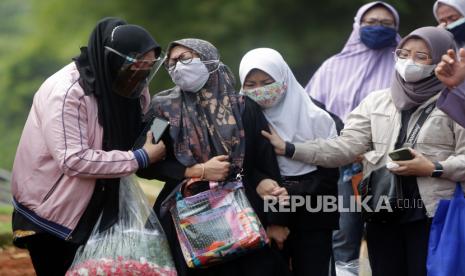  Kerabat berduka setelah pemakaman suami dan ayah mereka yang meninggal karena komplikasi penyakit COVID-19 di pemakaman di Depok, Senin (9/8/2021).. Pemerintah Indonesia belum memutuskan untuk melanjutkan atau melonggarkan penerapan pembatasan aktivitas masyarakat level 4 ( PPKM) yang akan berakhir pada 09 Agustus 2021. Tingginya angka kematian Covid-19 di Indonesia bahkan membuat Organisasi Kesehatan Dunia (WHO) memberikan catatan khusus.