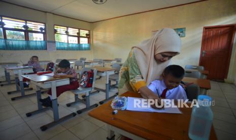 Tiga murid mengikuti kegiatan belajar di SDN 23 Lolong Padang, Sumatera Barat, Kamis (13/7/2023). Awal tahun ajaran baru, murid kelas 1 di sekolah tersebut hanya berjumlah tiga orang, meliputi dua murid baru dan satu murid tinggal kelas, akibat adanya kebijakan sistem zonasi pada Penerimaan Peserta Didik Baru (PPDB) karena di sana terdapat SDN lain yang berdekatan dan lokasi sekolah yang dekat dengan pantai.   