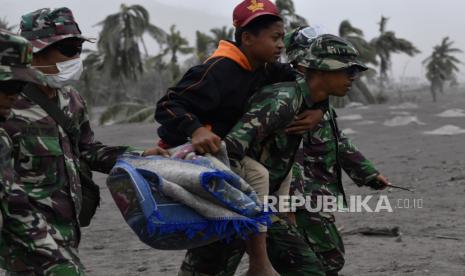 Prajurit TNI mengevakuasi seorang anak saat operasi pencarian korban di Desa Sumberwuluh, Lumajang, Jawa Timur, Senin (6/12/2021). Berdasarkan laporan Badan Nasional Penanggulangan Bencana (BNPB), jumlah korban meninggal dunia sampai Minggu (5/12) sore berjumlah 14 orang dan operasi pencarian korban oleh tim SAR gabungan masih terus berlangsung. 