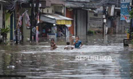 Anak-anak bermain saat banjir mengenangi (ilustrasi).