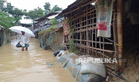 Pengungsi Rohingya berjalan di jalan di kamp pengungsi Rohingya nomor 4 yang terendam banjir setelah hujan lebat di Cox