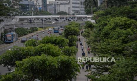 Pekerja berjalan saat jam pulang kerja di kawasan bisnis Sudirman-Thamrin, Jakarta, Senin (11/1). Wakil Gubernur DKI Jakarta Ahmad Riza Patria mengaku setuju dengan pernyataan Presiden Joko Widodo yang menyebut pelaksanaan PPKM belum efektif menurunkan angka penyebaran Covid-19. Menurut Ariza, kasus virus corona di Ibu Kota masih cukup tinggi salah satunya karena terjadi libur panjang akhir tahun 2020 lalu. 