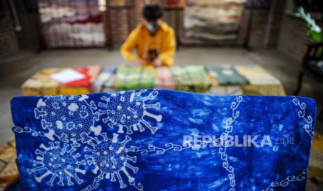 Pekerja merapikan baju motif batik bergambarkan virus Corona di Batik Komar, Bandung, Jawa Barat, Senin (11/5/2020). Produksi batik bermotif virus Corona tersebut merupakan salah satu bentuk keprihatinan perajin terhadap wabah COVID-19 serta salah satu ekspresi perajin untuk melawan COVID-19 dengan kreativitas