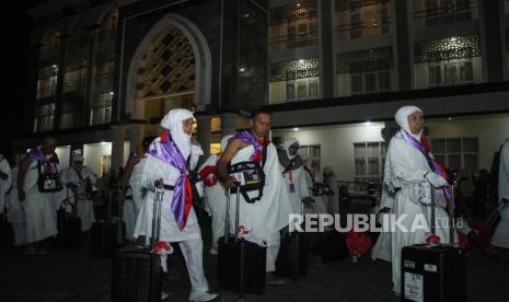 Jamaah haji berjalan menuju aula pemberangkatan.