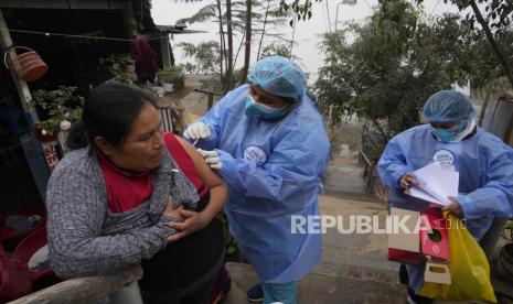 Seorang petugas kesehatan memberi Marlith Fasabi dosis vaksin flu dan vaksin Moderna untuk COVID-19 selama kampanye vaksinasi dari pintu ke pintu di lingkungan Ticlio Chico di pinggiran Lima, Peru, pada hari resmi pertama musim dingin, Selasa , 21 Juni 2022. Moderna mengumumkan vaksin booster khusus omicron tersedia Agustus mendatang.