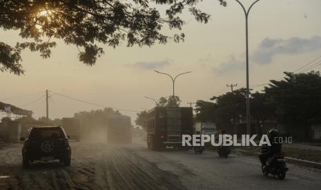 Sejumlah pengendara roda dua dan truk melintas di jalan berpasir di Jalan Lingkar Selatan, Kota Cilegon, Banten, Sabtu (30/3/2024). Jalan yang menjadi jalur utama untuk pemudik motor menuju pelabuhan Ciwandan tersebut dipenuhi pasir sehingga mengganggu kenyamanan dan kemanan pengendara terutama roda dua. 