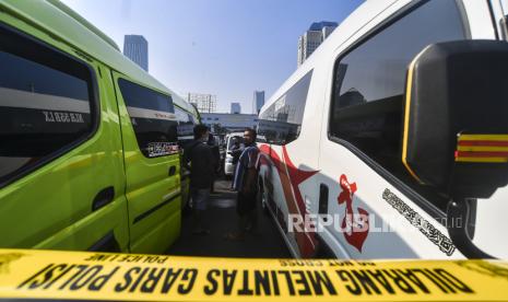 Pemilik kendaraan travel gelap menunggu hasil pemeriksaan usai diamankan petugas kepolisian di Lapangan Presisi Dit Lantas PMJ, Jakarta, Kamis (29/4/2021). Dit Lantas PMJ berhasil menangkap dan menyita sebanyak 115 kendaraan travel gelap yang beroperasi di wilayah Jakarta dan sekitarnya. 