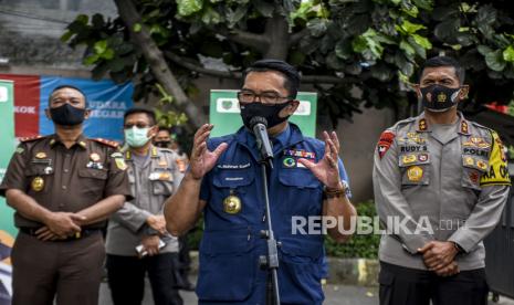 Gubernur Jawa Barat Ridwan Kamil (tengah) didampingi Kapolda Jabar Irjen Rudy Sufahriadi (kanan) dan Kepala Kejati Jabar Ade Eddy Adhyaksa (kiri) memberikan keterangan pers usai menjalani uji klinis fase tiga vaksin Covid-19 di Puskesmas Garuda, Jalan Dadali, Kota Bandung, Senin (14/9). Gubernur Jawa Barat Ridwan Kamil bersama Kapolda Jabar Irjen Rudy Sufahriadi, Pangdam III/Siliwangi Mayjen TNI Nugroho Budi Wiryanto dan Kepala Kejati Jabar Ade Eddy Adhyaksa menjalani penyuntikan kedua sebagai relawan uji klinis fase tiga vaksin Covid-19. Foto: Abdan Syakura/Republika