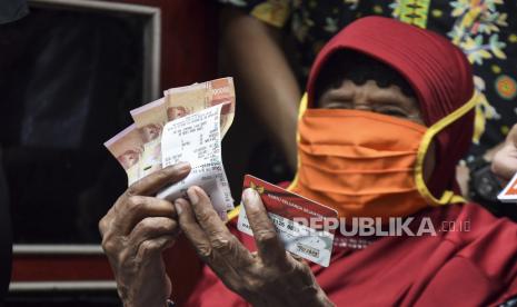 Warga Lanjut usia (Lansia) dari Keluarga Penerima Manfaat (KPM) menunjukkan uang bantuan Program Keluarga Harapan (PKH) di Bekasi, Jawa Barat. Mulai besok (8/2), pemerintah memulai program vaksinasi Covid-19 untuk lansia. (ilustrasi)