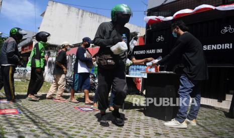 Warga mengantre untuk mengambil makanan gratis di Kopi Dodol, Jatipadang, Jakarta, Ahad (15/8/2021). Kegiatan berbagi makanan gratis bagi masyarakat yang melintas di kawasan tersebut sebagai bentuk kepedulian kepada warga yang perekonomiannya terdampak pandemi COVID-19. 