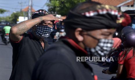 Pecalang memantau aktivitas warga saat kegiatan sosialisasi dan edukasi pendisiplinan penggunaan masker. Penutupan Pasar Galiran dilakukan untuk memutus mata rantai penyebaran Covid-19. Ilustrasi. 