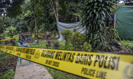 Petugas kepolisian berada di dekat makam Almarhum Iim Halimah saat proses ekshumasi di TPU Saar Mutiara Cililin, Jalan Saar Mutiara, Desa Karangtanjung, Cililin, Kabupaten Bandung Barat, Rabu (25/1/2023). Proses ekshumasi atau pembongkaran makam tersebut guna membuat terang kasus serta menyelidiki penyebab kematian Iim Halimah yang diduga menjadi salah satu korban dari pembunuhan berantai atau serial killer Wowon Erawan cs. Saat ini, total korban tewas dari kasus pembunuhan berantai tersebut mencapai sembilan orang.