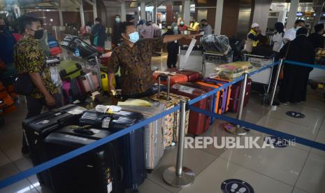 Petugas tour n travel merapikan koper milik calon jamaah umroh di Terminal 3 Bandara Soekarno Hatta, Tangerang, Banten, Ahad (1/11). Ratusan jamaah diberangkatkan ke tanah suci pada Ahad (1/11). Hal ini merupakan pemberangkatan perdana setelah umroh ditutup pada februari akibat pandemi Covid-19. 