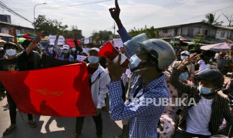  Para pengunjuk rasa memberi hormat tiga jari saat mereka membawa bendera serikat mahasiswa selama protes terhadap kudeta militer di Mandalay, Myanmar, 21 Mei 2021.