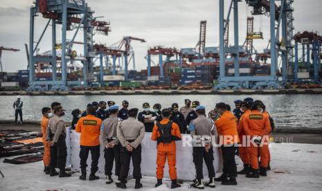 Anggota Polri dan Basarnas melihat proses identifikasi jenazah dan serpihan pesawat Sriwijaya Air PK-CLC nomor penerbangan SJ 182 rute Jakarta-Pontianak pada hari keenam Operasi SAR pesawat tersebut di Dermaga JICT, Tanjung Priok, Jakarta Utara, Kamis (14/1/2021). 