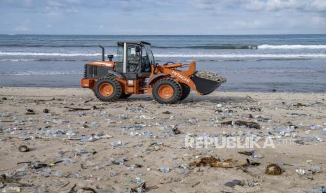  Pekerja membersihkan tumpukan puing dan sampah plastik. ilustrasi