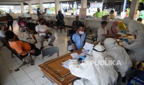 Petugas medis Puskesmas Kecamatan Pasar Minggu mendata warga saat tes Swab di Terminal Pasar Minggu, Jakarta, Selasa (16/6). Tes swab untuk memutus mata rantai penyebaran Covid-19 itu diperuntukan bagi para pedagang pasar, Sopir angkutan umum, tukang ojek dan warga di sekitar Pasar Minggu