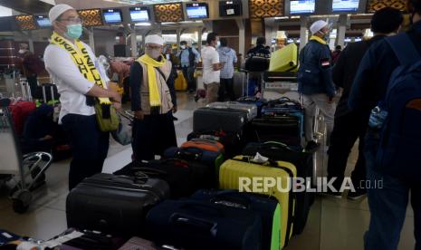 12 Jamaah Umroh Perdana Positif Covid-19, Batal Berangkat. Calon Jamaah umroh merapikan koper miliknya di Terminal 3 Bandara Soekarno Hatta, Tangerang, Banten, Ahad (1/11). Ratusan jamaah diberangkatkan ke tanah suci pada Ahad (1/11). Hal ini merupakan pemberangkatan perdana setelah umroh ditutup pada februari akibat pandemi Covid-19. Prayogi/Republika.