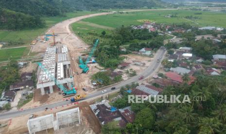 Foto udara proyek pembangunan jembatan layang Tol Padang - Pekanbaru di Jalan Raya Padang - Bukittinggi, Pasar Usang, Kabupaten Padangpariaman, Sumatera Barat, Kamis (8/7/2021). Data PT Hutama Karya (Persero), progres pembangunan tol itu telah mencapai 41,218 persen dan difokuskan pada penyelesaian jembatan layang dengan panjang 150 meter di posisi Sta 6+050 - Sta 6+200. 