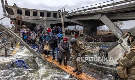  Orang-orang menyeberangi jembatan yang hancur saat mereka melarikan diri dari kota garis depan Irpin, wilayah Kyiv (Kiev), Ukraina, 07 Maret 2022. Irpin, kota yang terletak di dekat kota Kyiv, mengalami pertempuran sengit selama hampir seminggu antara militer Ukraina dan Rusia yang memaksa. ribuan orang untuk melarikan diri dari kota.