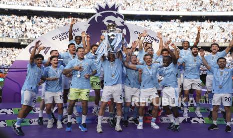 Manchester City players celebrate with the Premier League trophy after the English Premier League soccer match between Manchester City and West Ham United at the Etihad Stadium in Manchester, England, Sunday, May 19, 2024. Manchester City clinched the English Premier League on Sunday after beating West Ham in their last match of the season.  