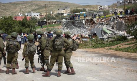 Bagaimana Orang Israel Menjadi Korban dari Medianya Sendiri. Tentara Israel berjalan melewati puing-puing rumah Palestina yang dibongkar oleh pasukan Israel karena dibangun tanpa izin, di desa Ain Shibli di Lembah Jordan Tepi Barat, Rabu, Maret. 10, 2021.