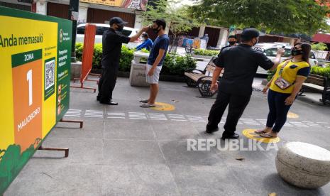 Petugas megukur suhu tubuh pengunjung sebelum memasuki kawasan wisata Malioboro, Yogyakarta, Ahad (19/7). Protokol kesehatan Covid-19 menjadi panduan wajib di tempat wisata Yogyakarta. wajib menggunakan masker, mencuci tangan, dan pengukuran suhu tubuh selalu dilakukan oleh petugas. Ini dilakukan untuk menekan penyebaran virus Covid-19. Dan Yogyakarta masih belum terbebas dari penambahan pasien Covid-19.