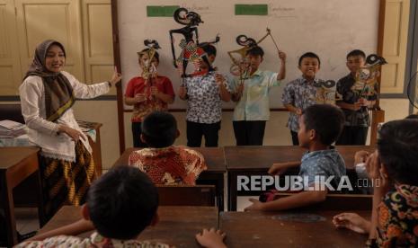 Guru menyampaikan pelajaran Aksara Jawa dengan alat peraga tokoh pewayangan di SD Negeri Kepatihan Solo, Jawa Tengah, Kamis (9/11/2023). Kegiatan belajar menulis dan membaca aksara Jawa dengan metode kreatif tersebut dilakukan guru setempat sebagai upaya efektif untuk melestarikan bahasa daerah serta menjaga keberlangsungan kebudayaan Jawa. 