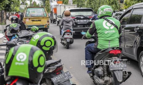 Seorang pengemudi Gojek mengendarai sepeda motornya di pinggir jalan di Medan, Sumatera Utara, Selasa (18/5). Perusahaan tumpangan Gojek dan perusahaan e-commerce Tokopedia telah mengumumkan merger dan membentuk perusahaan bernilai miliaran dolar, GoTo Group.