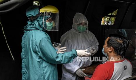 Petugas kesehatan melayani pasien di UPT Puskesmas Tamblong, Jalan Tamblong, Kota Bandung, Kamis (7/1). Dinas Kesehatan Kota Bandung menyiapkan sedikitnya 80 puskesmas untuk digunakan sebagai tempat kegiatan vaksinasi Covid-19 dengan 45 ribu dosis vaksin yang didistribusikan oleh Pemerintah Provinsi Jawa Barat dan akan disuntikkan terlebih dahulu bagi tenaga kesehatan. Foto: Abdan Syakura/Republika