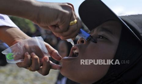 Seorang gadis menerima tetes vaksin dari petugas medis selama kampanye imunisasi polio di Sigli Town Square di Pidie, provinsi Aceh, Indonesia, Senin, 28 November 2022. Indonesia telah memulai kampanye melawan virus polio di provinsi konservatif negara itu setelah beberapa anak ditemukan terinfeksi penyakit yang sangat menular yang dinyatakan diberantas di negara itu kurang dari satu dekade lalu.