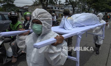 Petugas gabungan memanggul keranda berisi boneka pocong saat melaksanakan razia masker di Medan, Sumatera Utara, Selasa (29/9/2020). Razia masker dengan membawa boneka pocong tersebut untuk mengingatkan masyarakat agar tetap menerapkan protokol kesehatan guna mencegah penyebaran COVID-19.