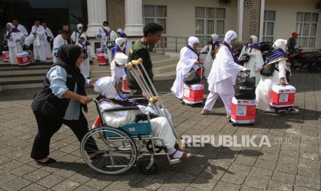 Petugas membantu calon haji asal Provinsi Papua menuju aula pemberangkatan di Asrama Haji Makassar, Sulawesi Selatan, Kamis (30/5/2024). Sebanyak 1.048 jamaah calon haji asal Provinsi Papua yang terbagi dalam tiga kelompok terbang embarkasi Makassar telah diberangkatkan menuju Jeddah, Arab Saudi untuk melaksanakan ibadah haji 1445 H. 