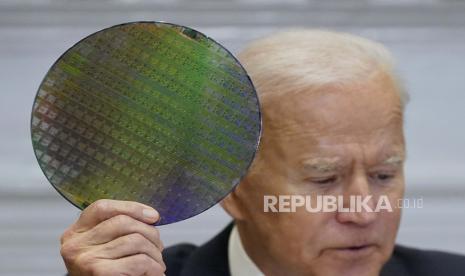 Presiden Joe Biden memegang wafer silikon saat dia berpartisipasi secara virtual dalam KTT CEO tentang Semikonduktor dan Ketahanan Rantai Pasokan di Ruang Roosevelt Gedung Putih, Senin, 12 April 2021, di Washington