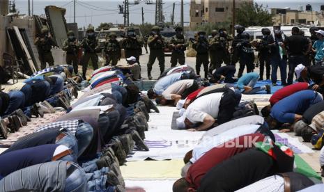 Para pengunjuk rasa Palestina berdoa di jalan selama demonstrasi menentang rencana Israel untuk mencaplok bagian-bagian Tepi Barat yang diduduki di desa Hares dekat kota Salfit di Tepi Barat utara, 26 Juni 2020. Pemerintah Israel dilaporkan bersiap-siap untuk mencaplok bagian-bagian Barat. Bank yang pertama kali dikuasai IDF dalam Perang Enam Hari 1967. Aneksasi hingga 30 persen dari wilayah Palestina yang diduduki, dianggap ilegal berdasarkan hukum internasional yang masih ada, akan memenuhi janji kampanye yang dijanjikan oleh Perdana Menteri Israel Benjamin Netanyahu selama pemilihan umum baru-baru ini. Langkah ini mendapat dukungan penuh dari pemerintahan Presiden AS Donald Trump yang menyatakan dukungannya untuk itu kembali pada bulan Januari tetapi sangat ditolak oleh sebagian besar aktor di wilayah bergolak tersebut.