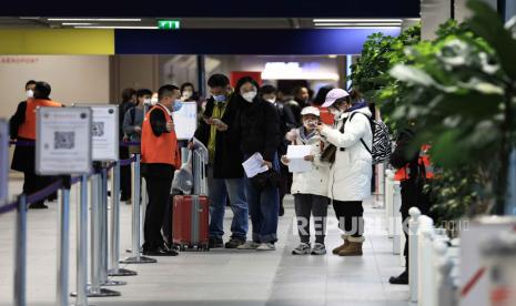  Penumpang yang datang dari China menunggu di depan area pengujian COVID-19 yang ditetapkan di bandara Roissy Charles de Gaulle, utara Paris, Ahad, 1 Januari 2023. Prancis mengatakan akan mewajibkan tes COVID-19 negatif untuk semua penumpang yang datang dari Tiongkok dan mendesak warga Prancis untuk menghindari perjalanan yang tidak penting ke Tiongkok.