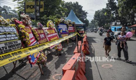 Warga berjalan di samping deretan karangan bunga pascaledakan bom bunuh diri di Mapolsek Astana Anyar, Jalan Astana Anyar, Kota Bandung, Jumat (9/12/2022). Karangan bunga tersebut sebagai bentuk penghargaan dan dukungan untuk Polri dalam memberantas terorisme, serta ucapan duka cita atas wafatnya Aiptu Anumerta Sofyan dalam peristiwa ledakan bom bunuh diri tersebut. Republika/Abdan Syakura