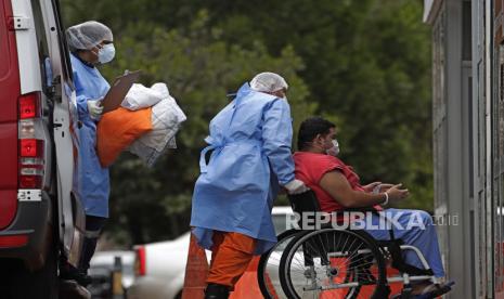 Brasil Laporkan 150 Ribu Kasus Covid-19 dalam Sehari. Petugas kesehatan kursi roda seorang pasien yang diduga menderita COVID-19 dari ambulans ke rumah sakit umum HRAN di Brasilia, Brasil, Kamis, 29 April 2021.